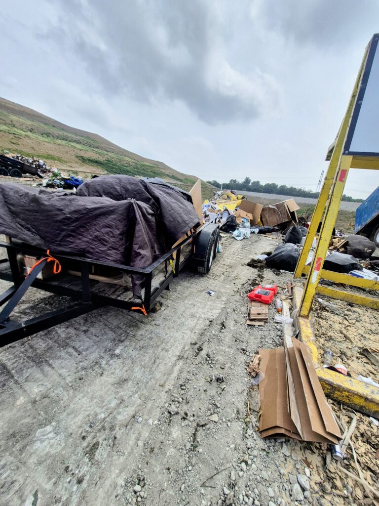 Junk removal team unloading debris from trailer at local Landfill in Fort Worth Texas
