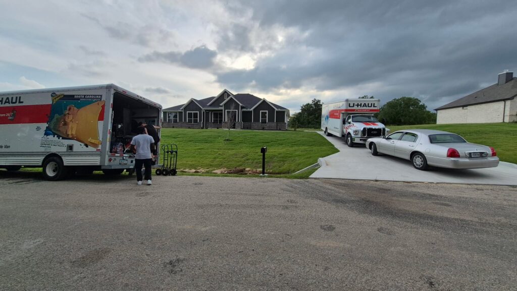 Two moving trucks from Sky Is The Limit Moving parked during a residential move from Roanoke, Texas to Boyd, Texas, operated by a CDL-certified driver ensuring safe and secure transportation.