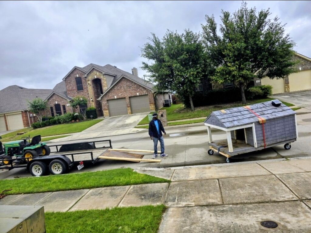 Sky Is The Limit Moving safely unloading a giant dog house from a trailer in the Keller Fort Worth area